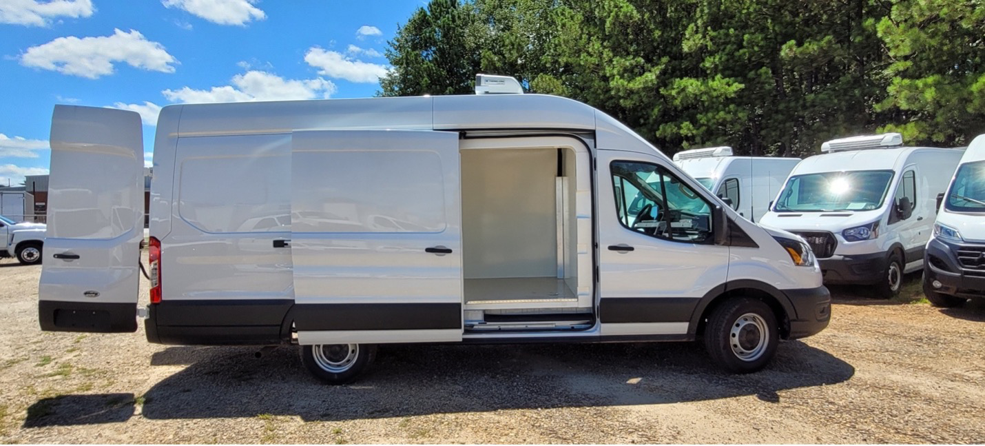 White semi-freezer refrigerated van with side and rear doors open, showing insulated cargo area for cold chain delivery.