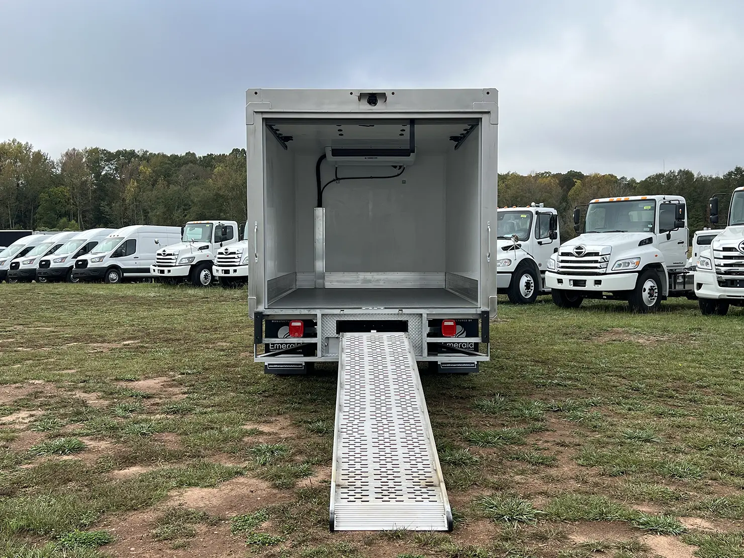 Rear view of an Emerald refrigerated truck with a walk-up ramp extended for easy loading and unloading.