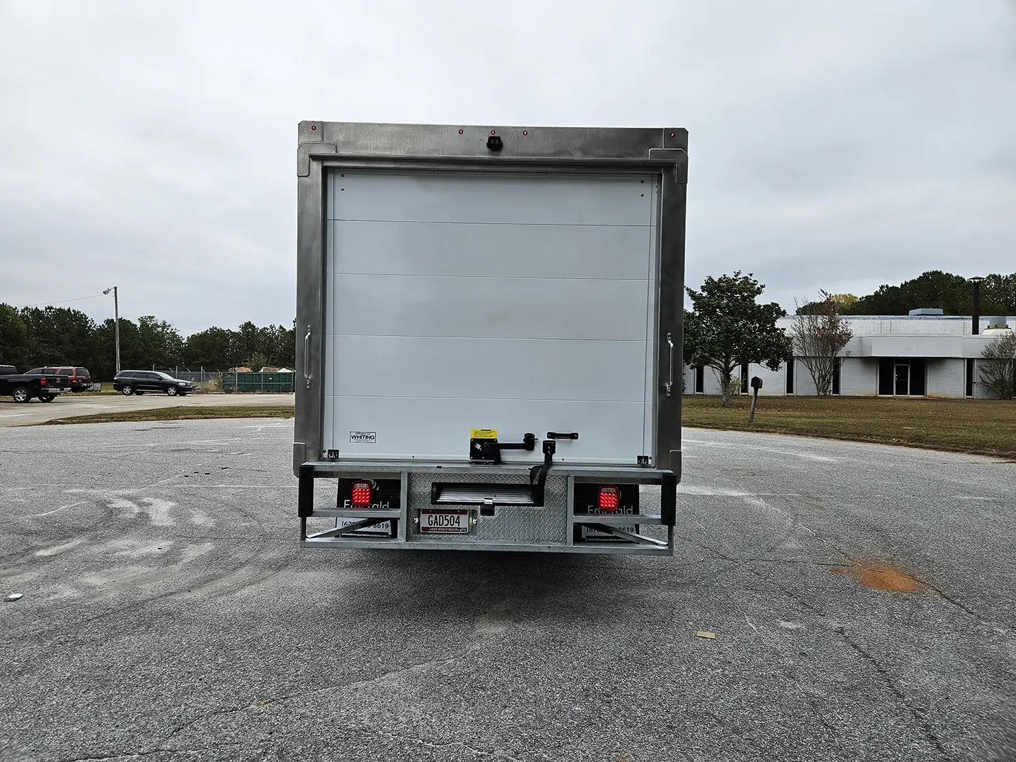 Rear view of an Emerald refrigerated box truck featuring a roll-up door for easy loading and unloading.